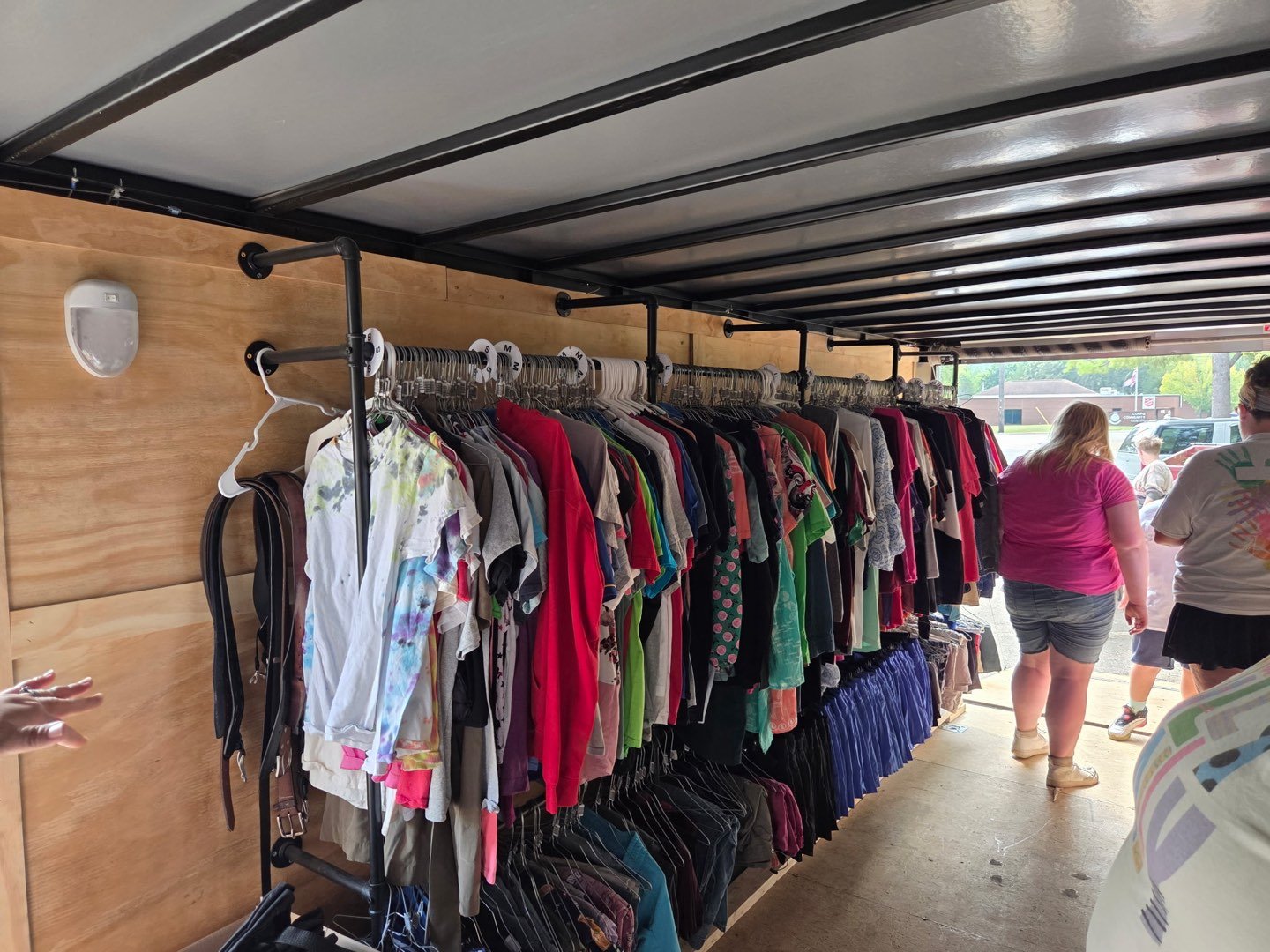 Racks of donated clothing lining the inside of the outreach trailer