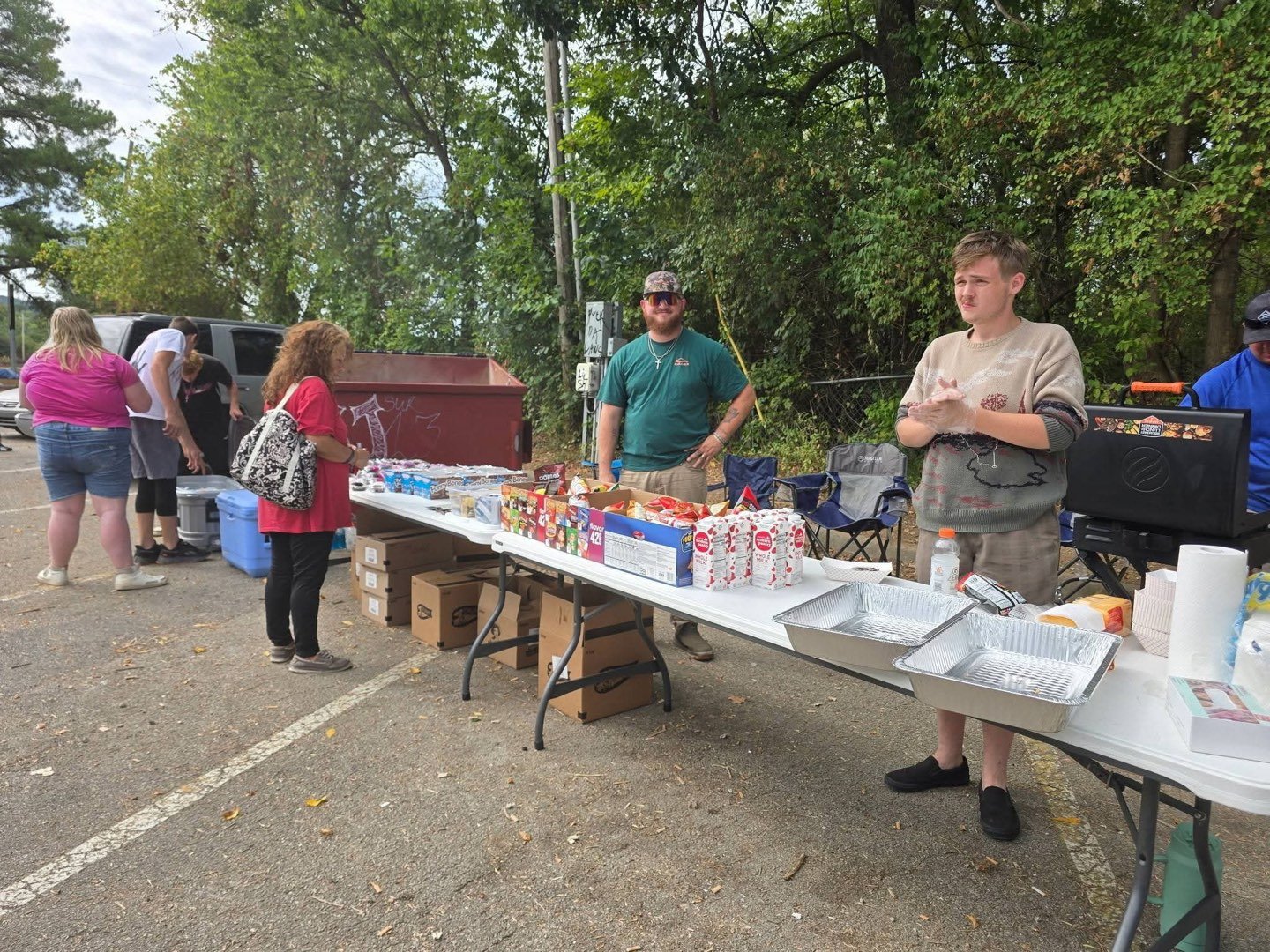 Volunteers behind a long table of food and drinks at an outreach event